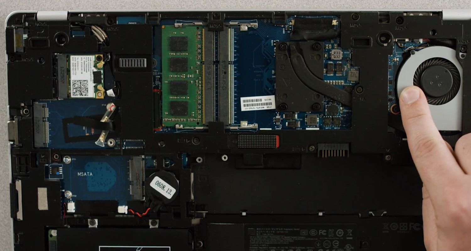 Finger touching an unpainted metal surface in the interior of a laptop to discharge static charge