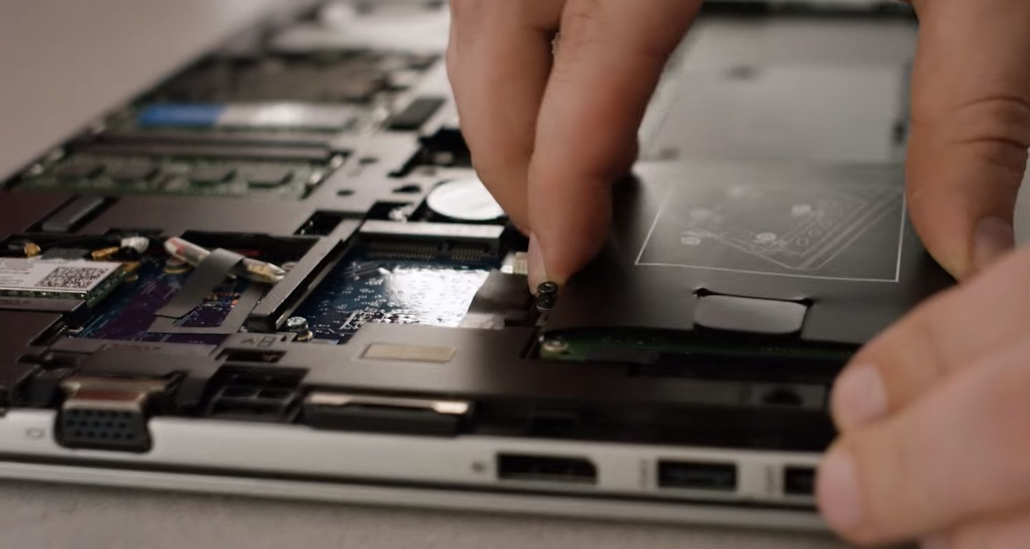 Crucial SSD being plugged in to the storage bay of a laptop