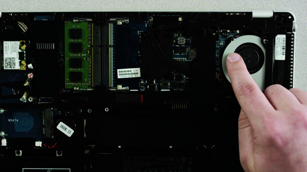 Una persona che tocca una superficie metallica non verniciata su un computer portatile per scaricare elettricità statica.